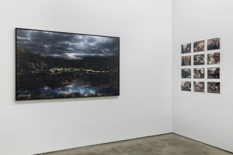 An installation view of Jasper de Beijer's exhibition, "The Brazilian Suitcase". Framed photographs are on the walls. Small pieces are arranged in a grid.