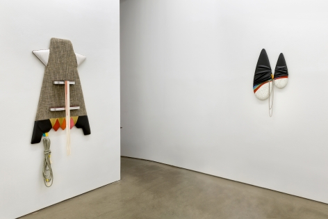 Installation view of Trish Tillman's exhibition "Stage Diver", which shows plush sculptures on the walls by a doorway