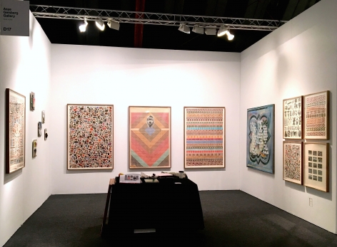 Installation view of the booth at Art Los Angeles Contemporary. Large works are on the wall and a table with sculptures is in the middle of the booth