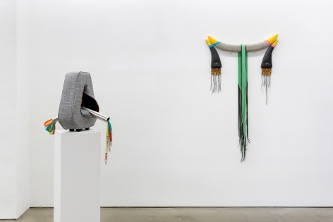 Installation view of Trish Tillman's exhibition "Stage Diver", which shows plush sculptures on the walls and on a floor pedestal.